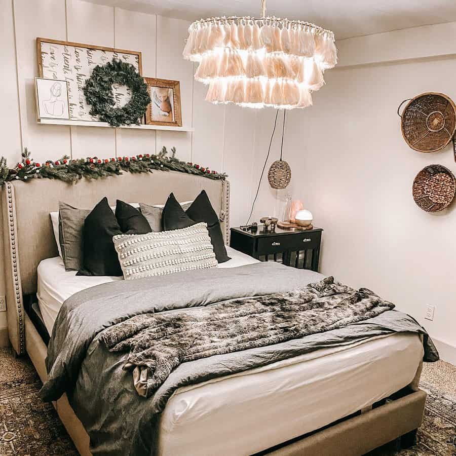 Cozy master bedroom with neutral tones, layered bedding, and festive greenery, creating a warm and inviting space with rustic charm