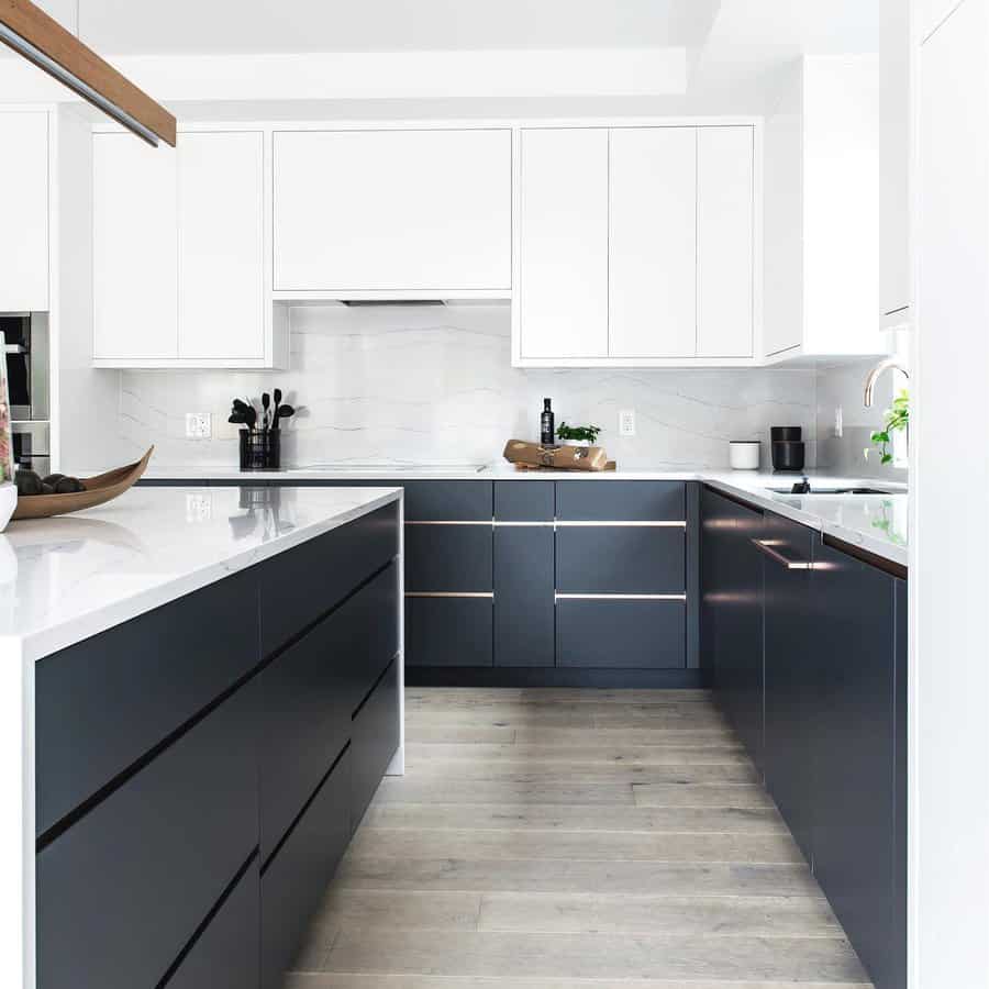 Modern kitchen with sleek white and black cabinets, white countertops, and wooden floor