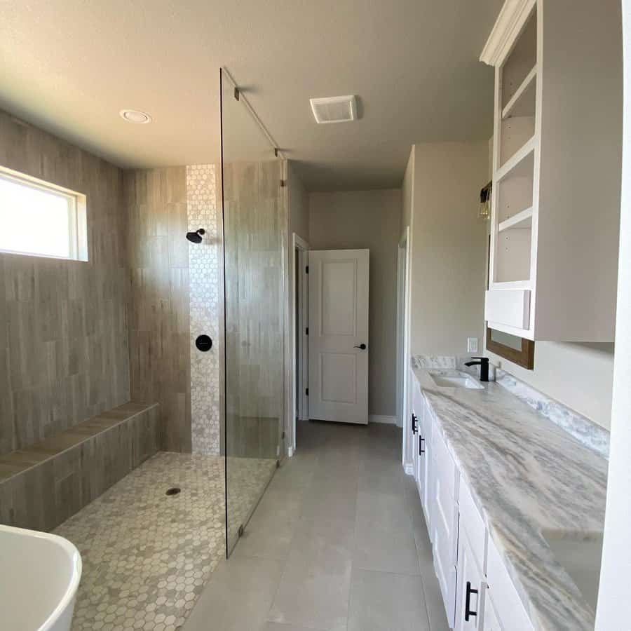 walk-in shower with mosaic tile accent
