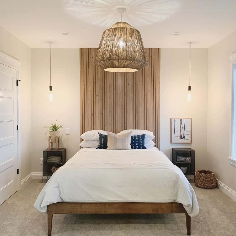 Minimalist bedroom featuring a wooden bed, white bedding, pendant lights, a woven lampshade, and a wooden accent wall