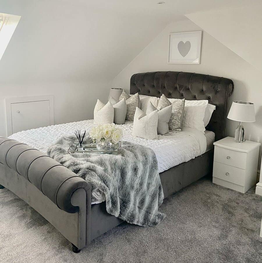 Luxurious attic bedroom with a tufted velvet bed, soft neutral tones, and plush textures. A cozy, elegant retreat with sophisticated decor.