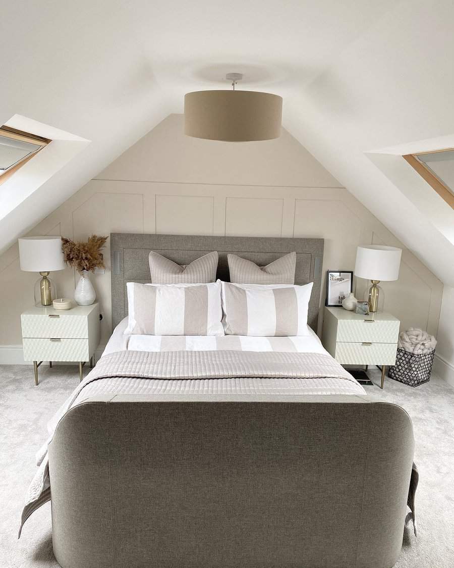 Modern attic bedroom with a neutral palette, skylights, and a cozy upholstered bed. Soft textures and elegant decor create a serene retreat.