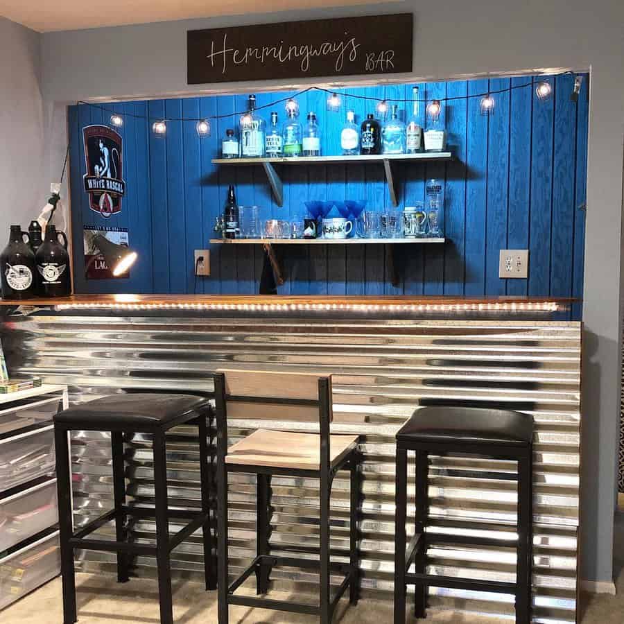 Metallic bar with blue backlit shelving and industrial stools