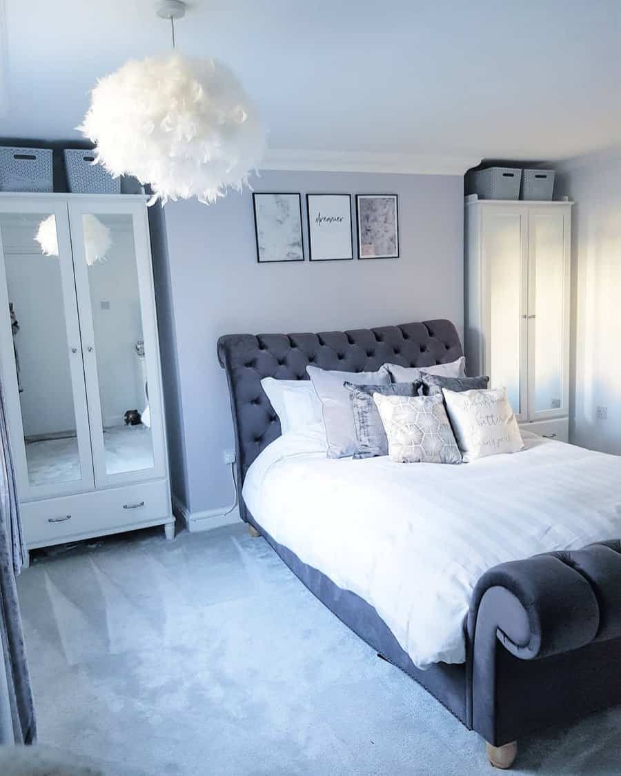 Bedroom in pastel shades with a velvet headboard and a feathered light