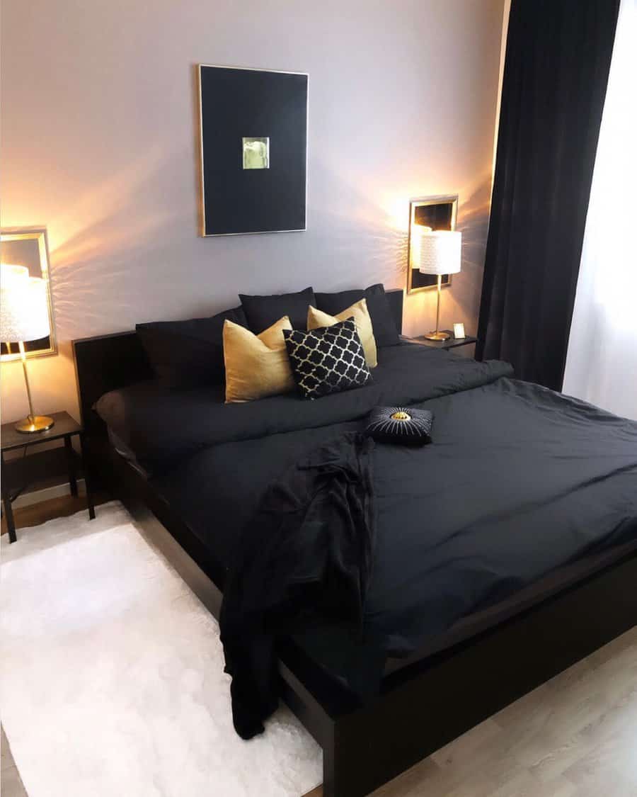 Modern bedroom with a black bed, gold and black pillows, abstract wall art, and lit table lamps on each side