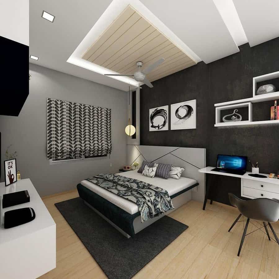 Modern bedroom with a gray, white, and black theme featuring a bed, desk with laptop, shelves, and patterned blinds on the window