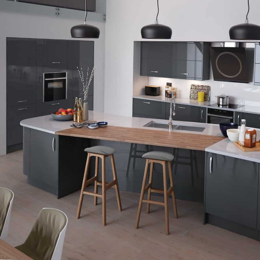 Sleek modern kitchen with a curved breakfast bar, dark glossy cabinetry, wood-accented seating area, black pendant lighting, and minimalist decor