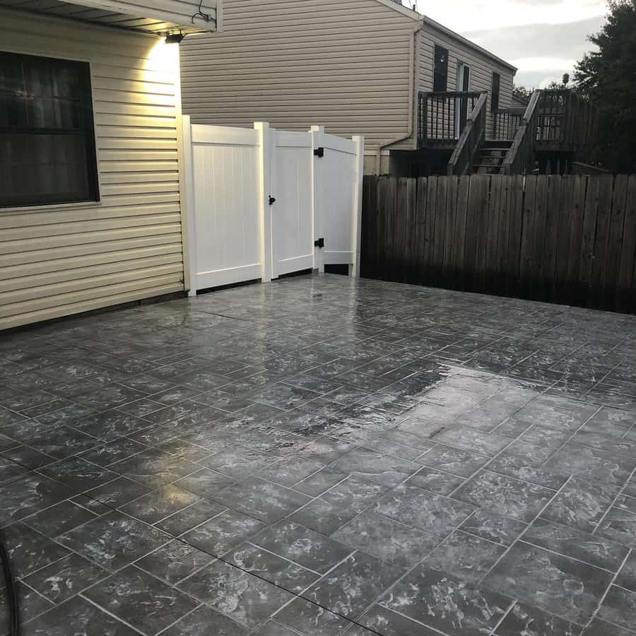 Tiled patio with white fence and house exterior