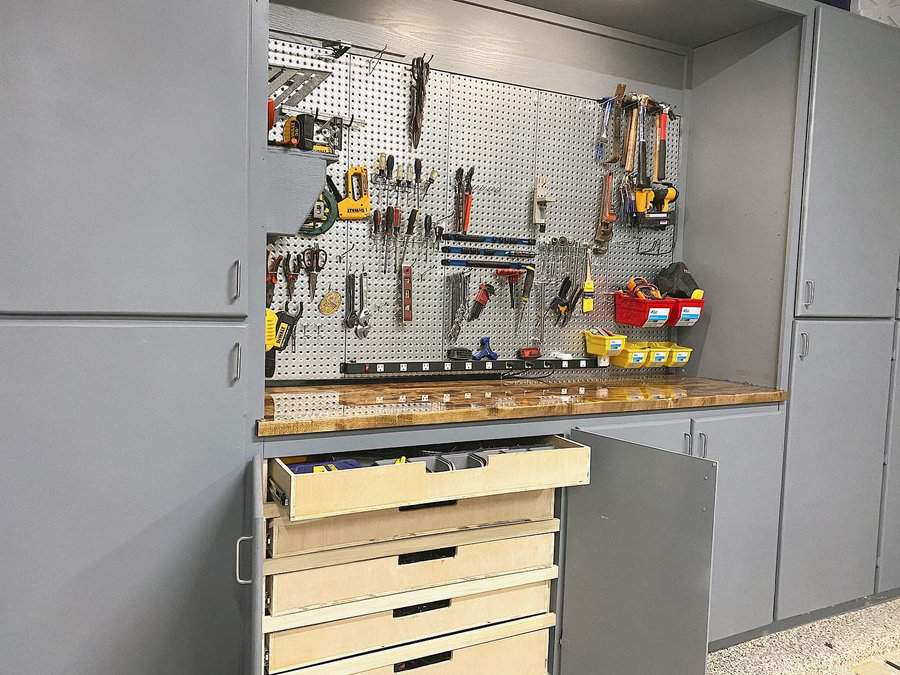 Workshop with tools on pegboard and open drawers