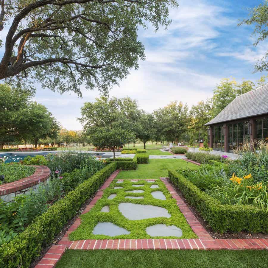 Expansive modern landscape featuring a vibrant green lawn framed by neatly trimmed hedges, stepping stones surrounded by lush ground cover, and a mix of colorful flowers and trees. Brick borders add structure and elegance, complementing the tranquil garden setting.