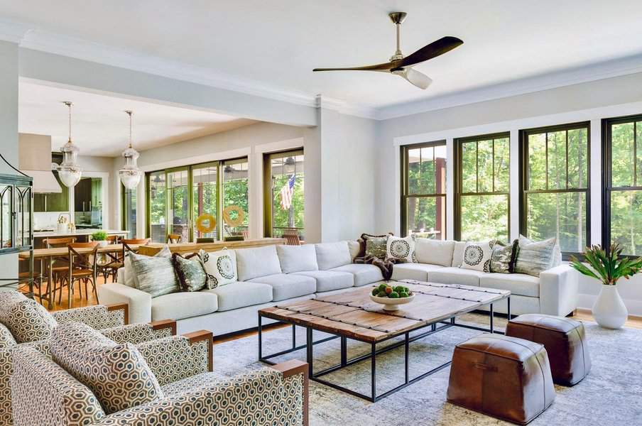 Open plan living area with sectional sofa and large windows