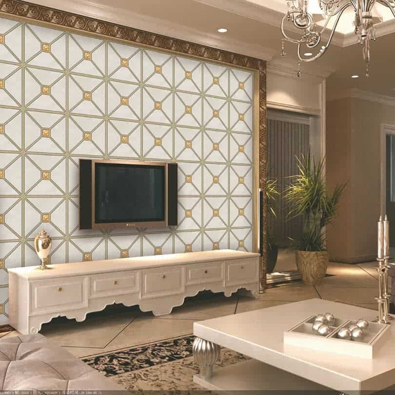 Elegant living room with geometric wallpaper, a wall-mounted TV, white ornate cabinet, potted plants, and a chandelier