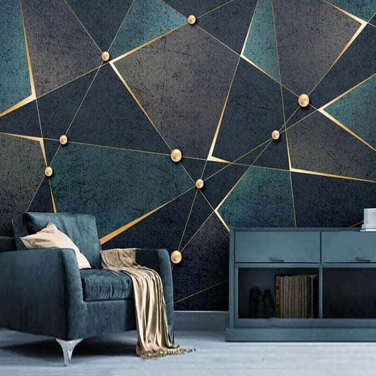 Modern living room with geometric wallpaper, dark teal sofa, beige cushions, and a matching cabinet; sophisticated and stylish decor