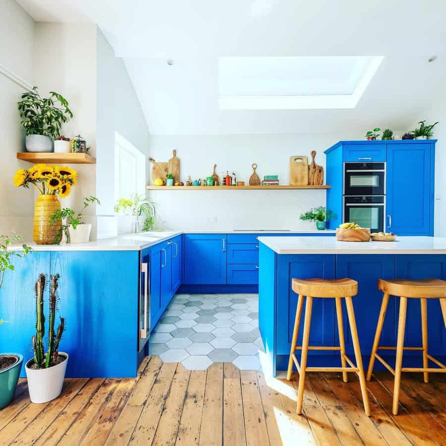 Bright kitchen with blue cabinets and wooden floor