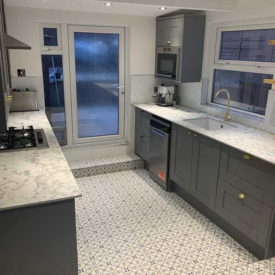 Grey kitchen with intricate tile floor and marble counters