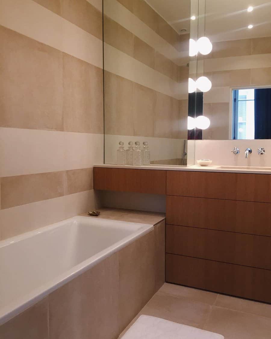 Minimalist bathroom with striped tiles and wooden cabinet