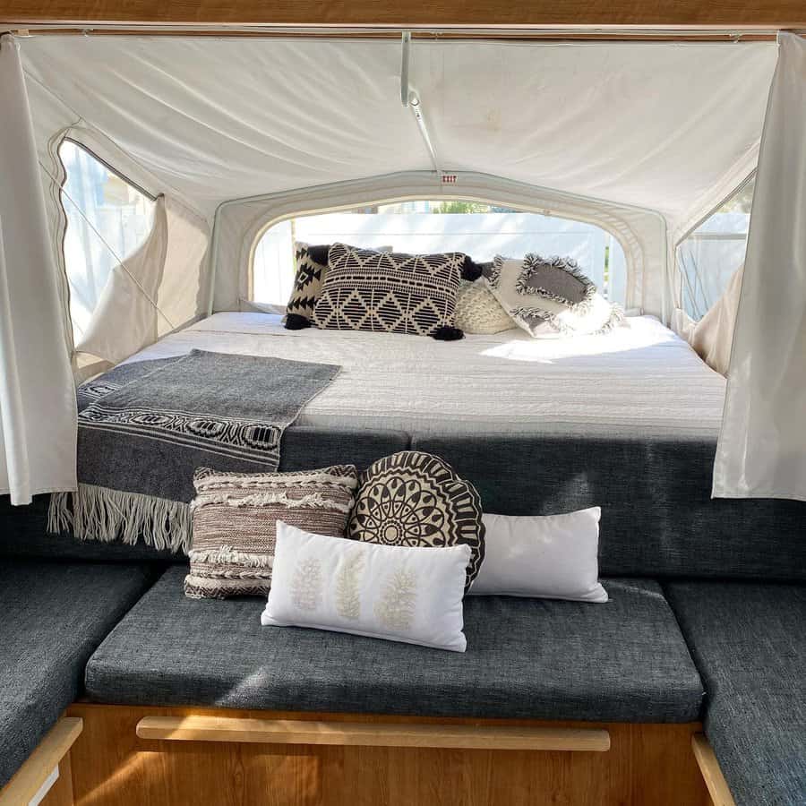 Pop up camper bed with stylish cushions and natural light