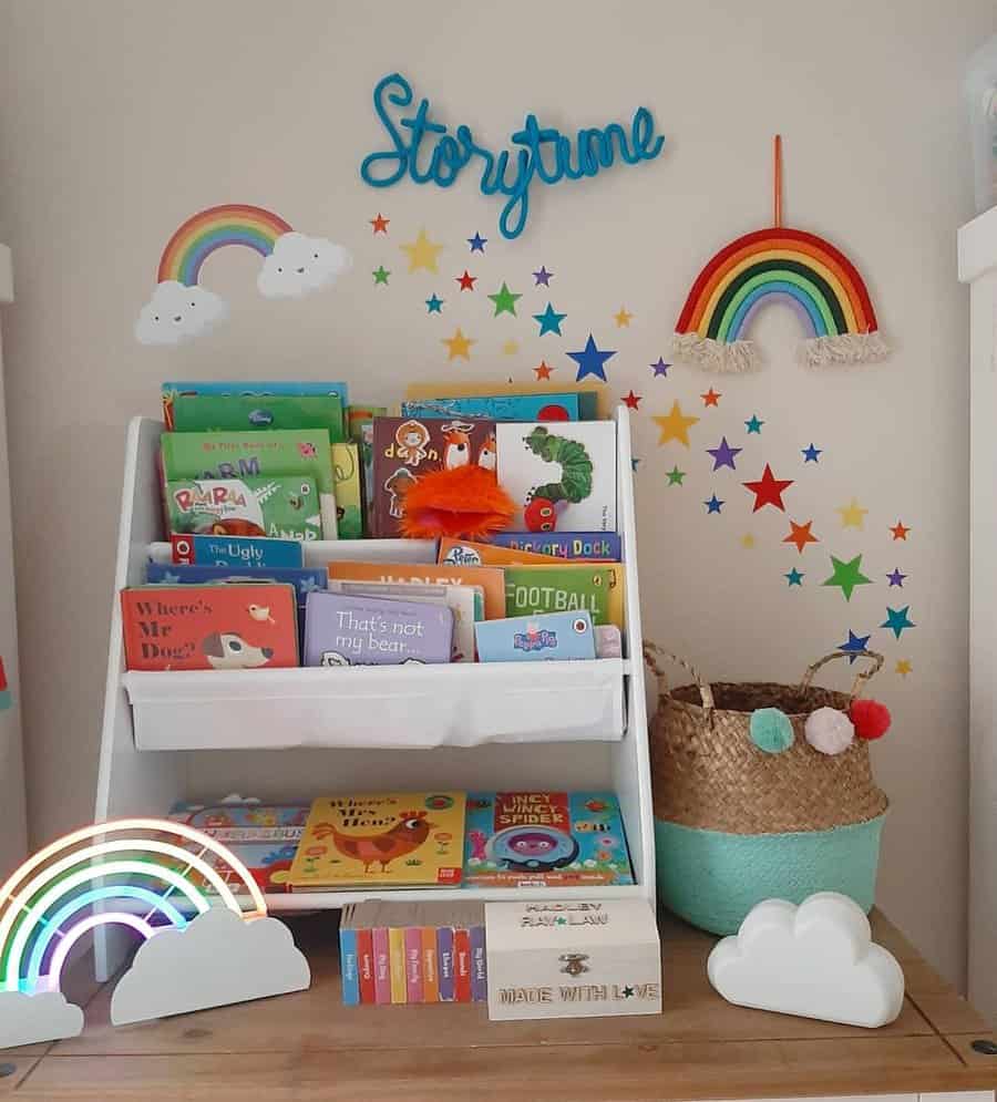 Colorful nursery reading corner with a white book rack filled with children's books, rainbow decorations, and a "Storytime" wall sign.