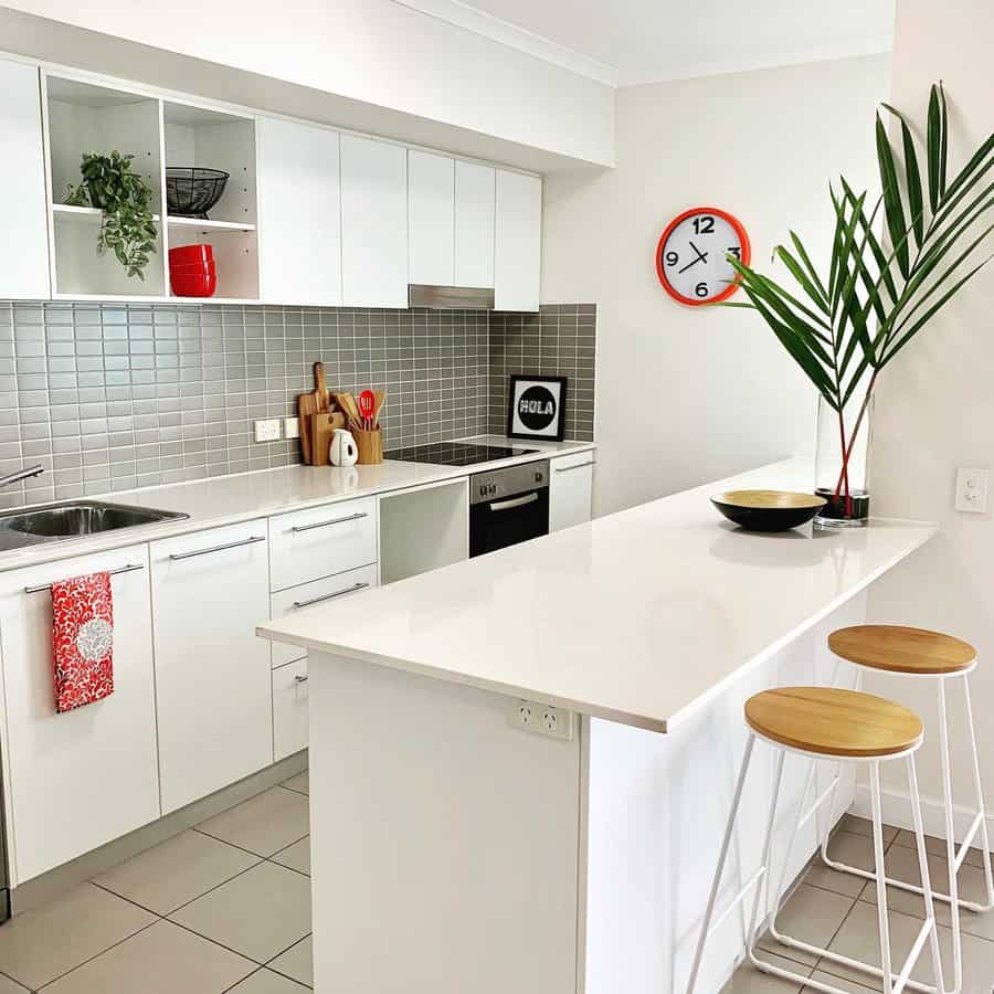white galley kitchen with a pop of red