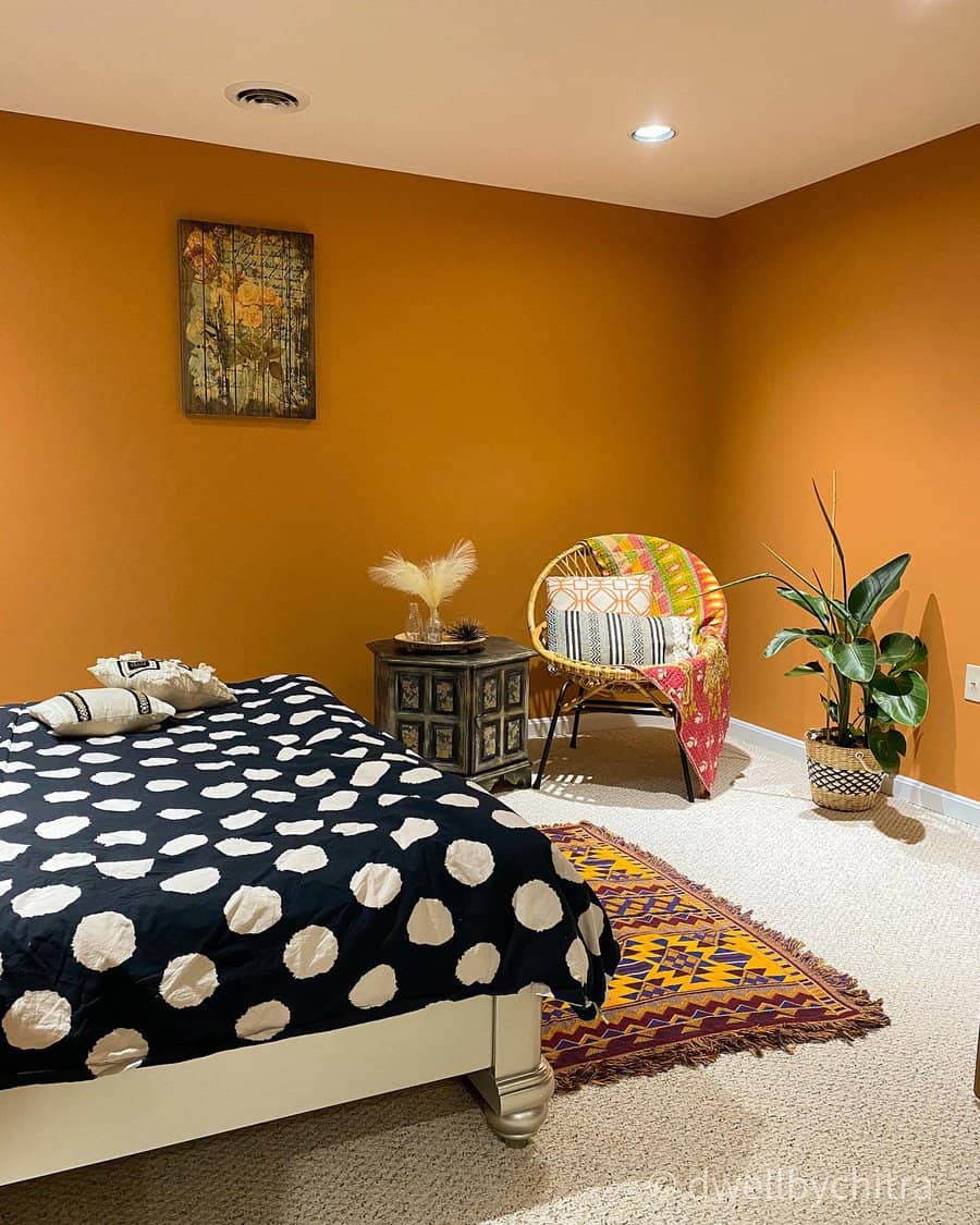 Boho inspired bedroom with orange walls and eclectic decor