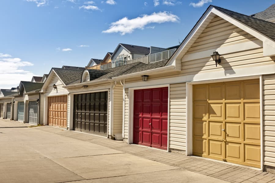 Row of houses with colorful garage doors under blue sky