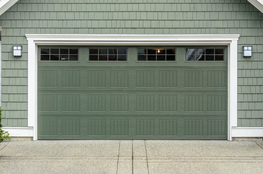 House with olive green garage door and white wall lamps