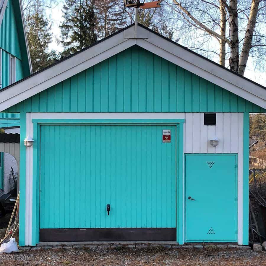 Quaint garage with turquoise doors and white trim