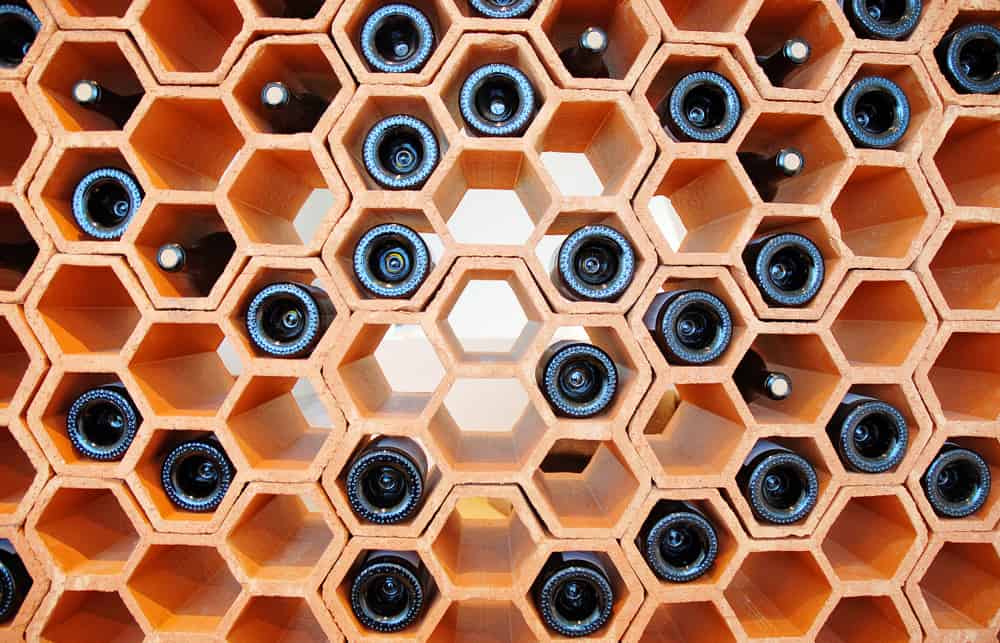 Hexagonal terracotta wine rack with bottles stored horizontally, creating a honeycomb pattern