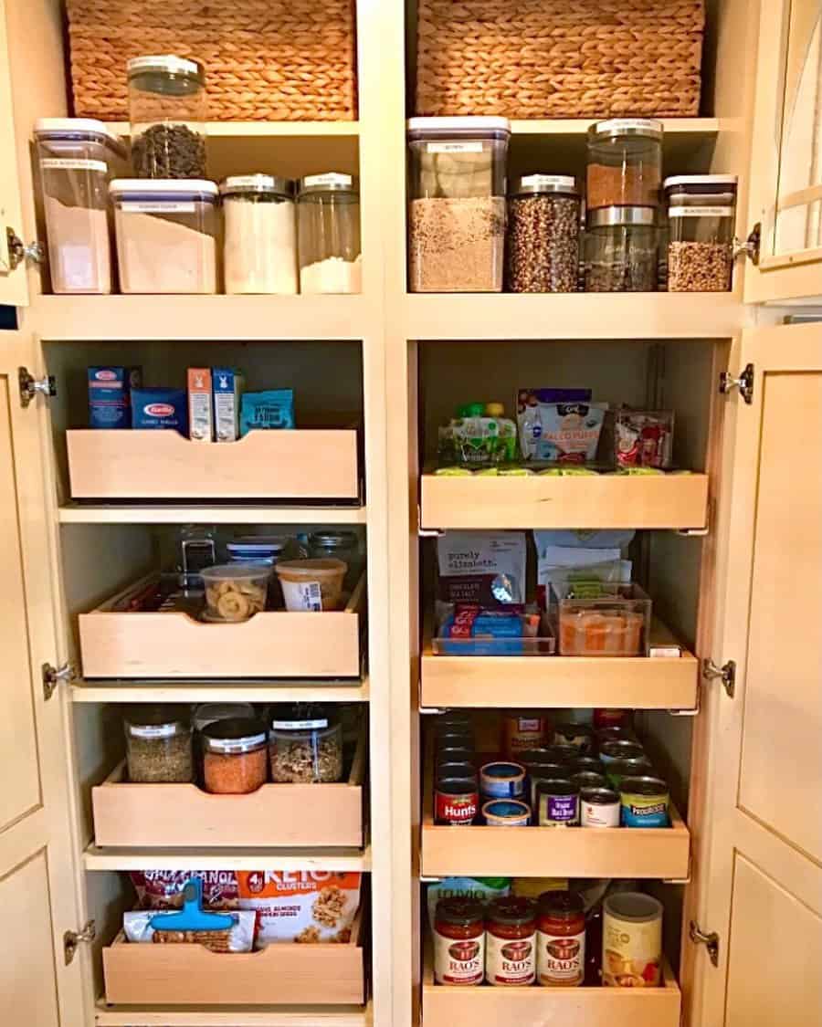 Well-organized pantry with labeled glass jars, woven baskets, and pull-out wooden drawers for efficient food storage and easy access