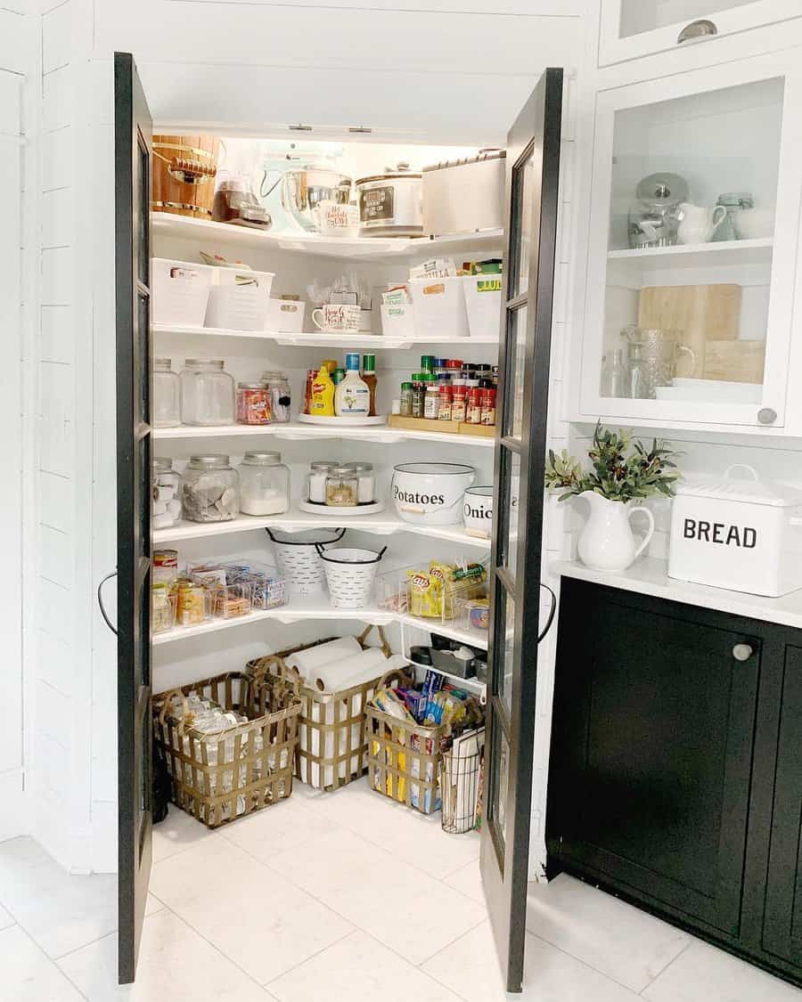 A well-organized pantry with black-framed doors, labeled bins, glass jars, and baskets, creating a tidy and efficient storage solution