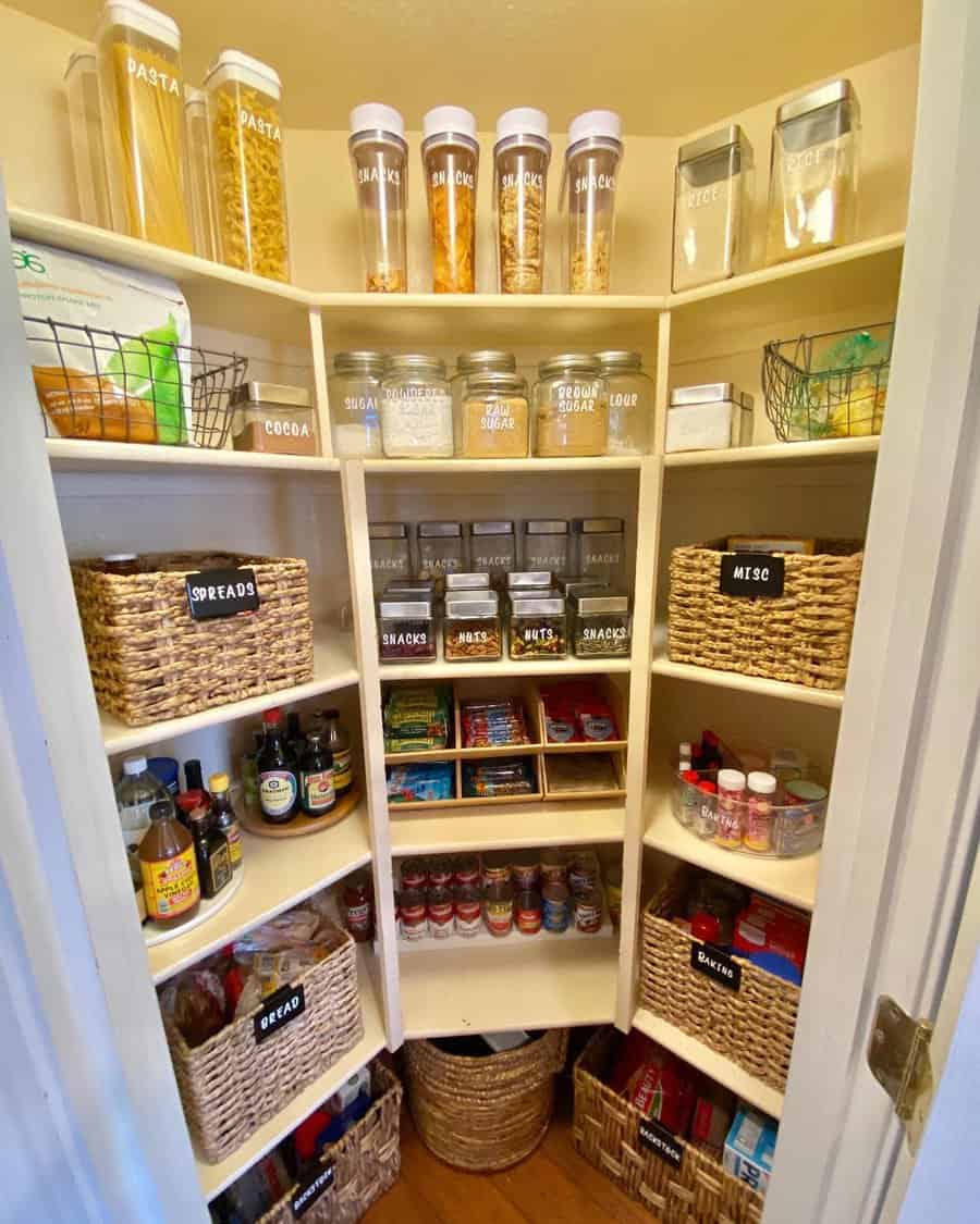 Organized pantry with labeled shelves, jars, and baskets filled with snacks, pasta, canned goods, and condiments