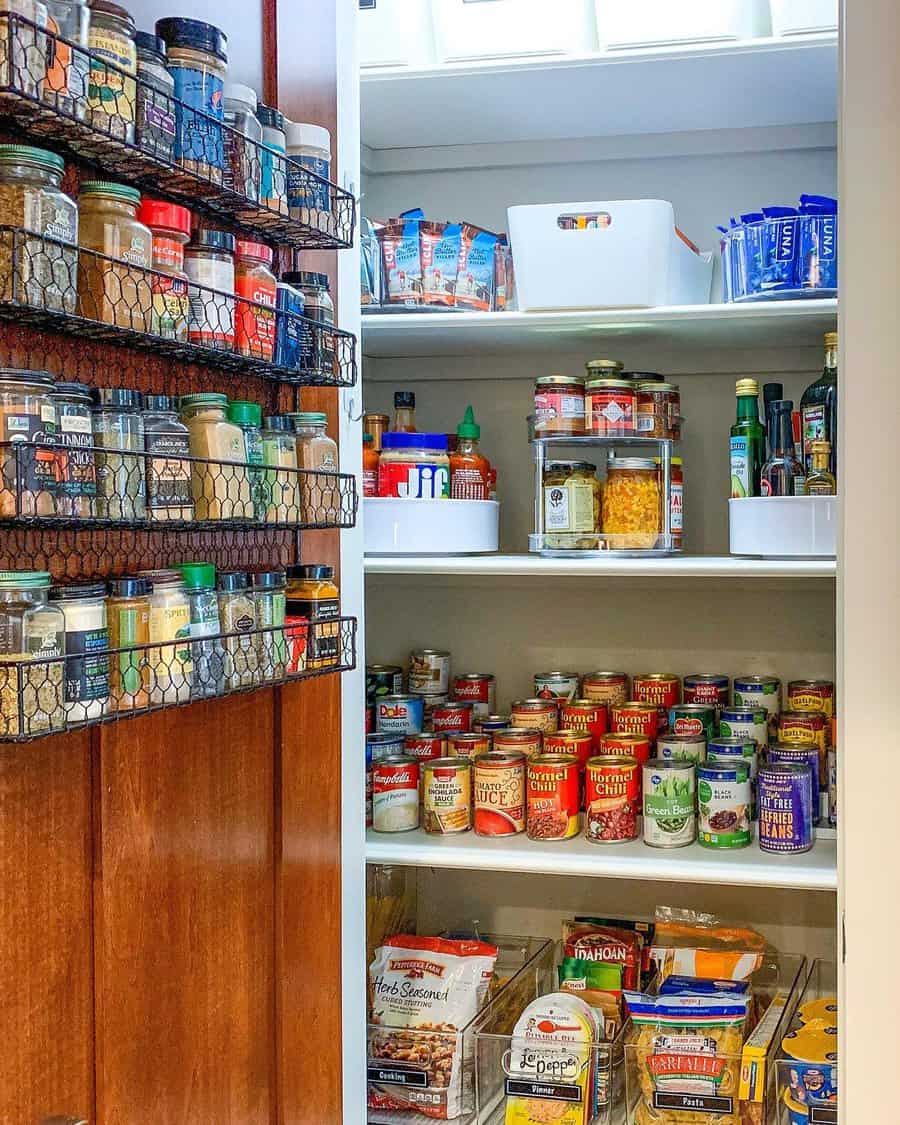 Organized pantry with neatly arranged spices, canned goods, and packaged foods on shelves and in baskets