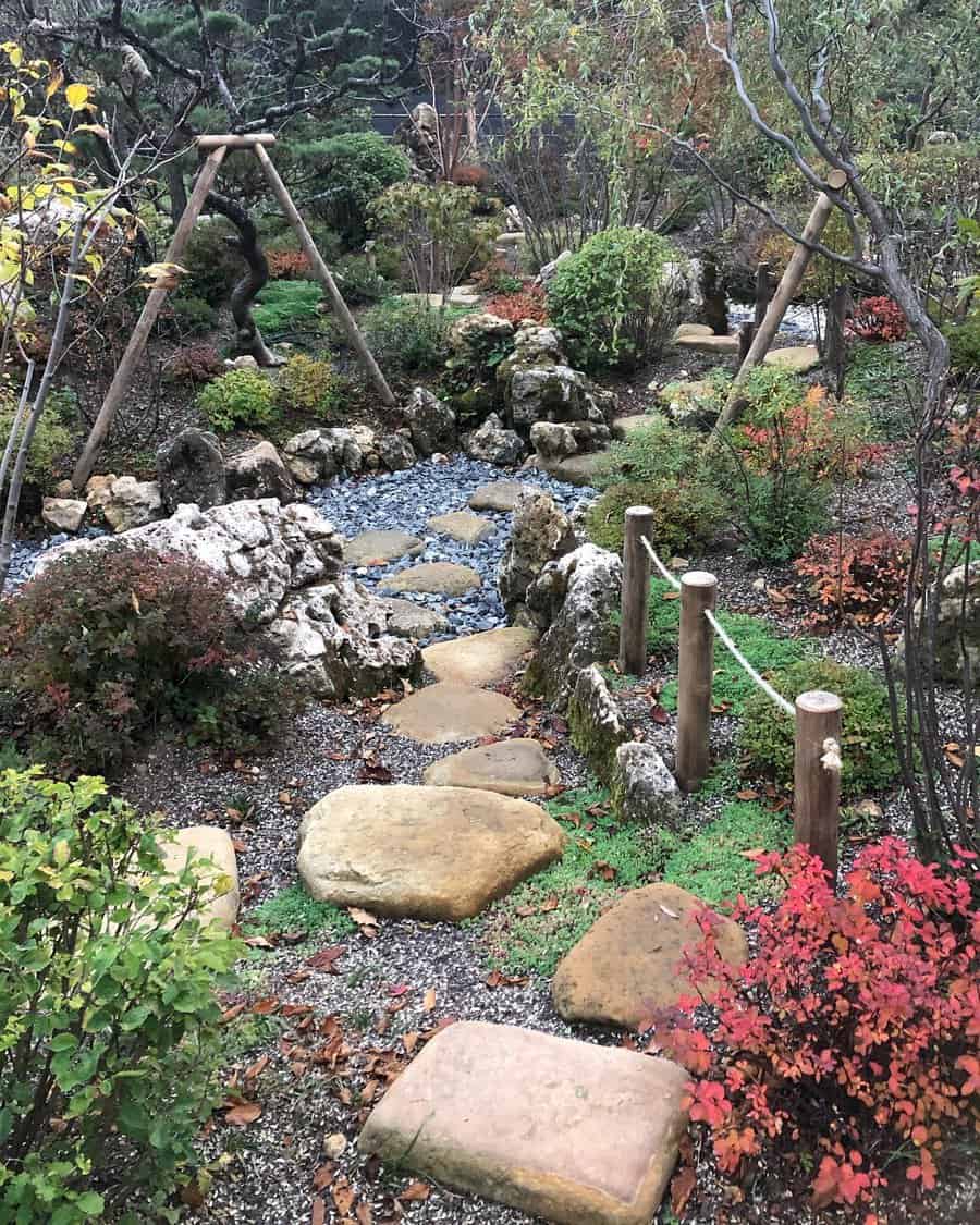 Japanese garden with stone path, lush greenery, autumn foliage, and a small dry stream