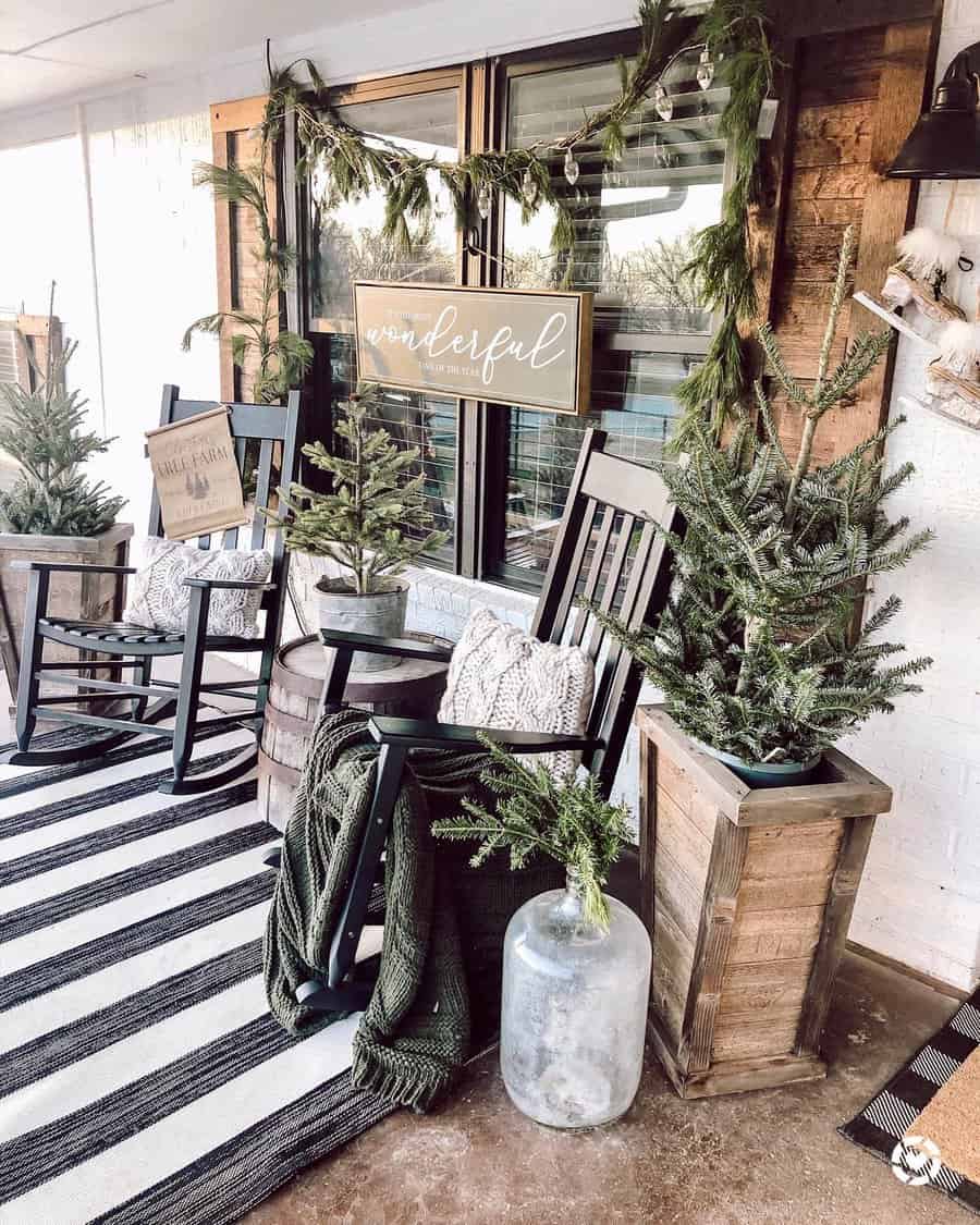 Cozy porch with rocking chairs, evergreen decorations, a striped rug, and a "Wonderful" sign, creating a festive atmosphere