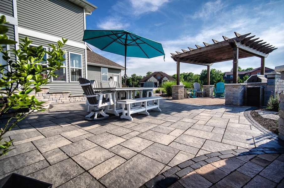 Spacious brick patio with pergola and outdoor furniture