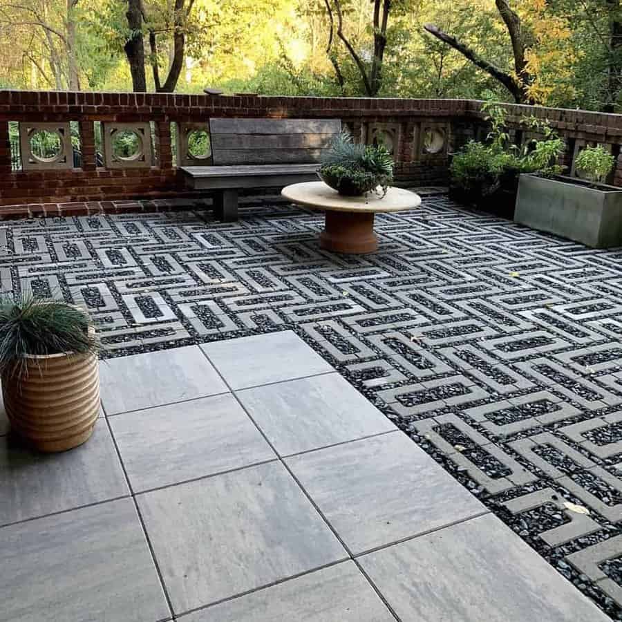 Patterned patio with bench seating and forested backdrop