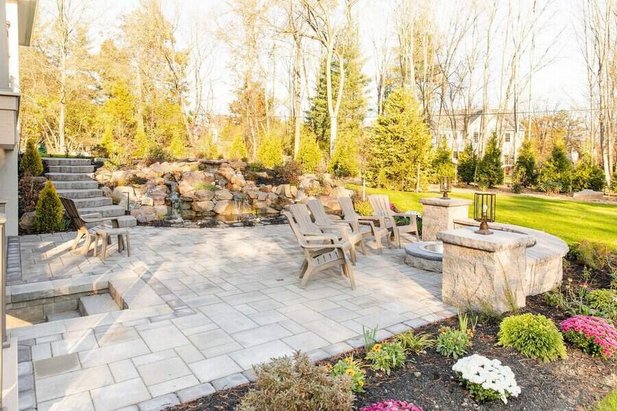 Spacious patio with fire pit and lush garden backdrop