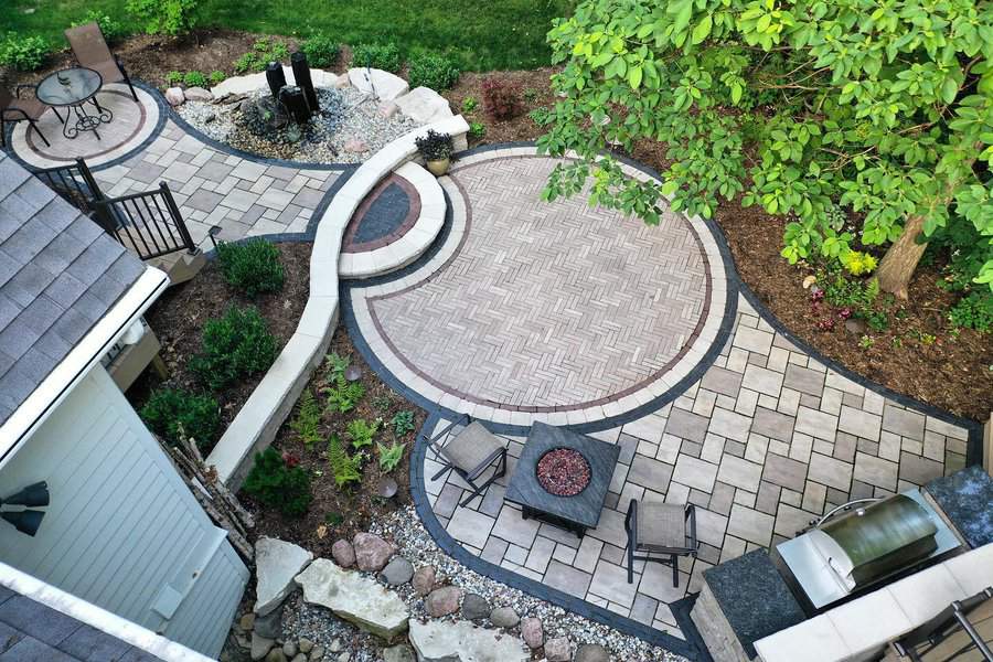 Aerial view of a curving paver patio with greenery