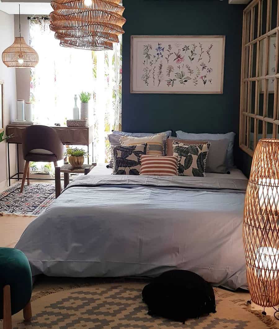 Boho Zen bedroom with a deep green accent wall, botanical prints, layered textiles, rattan lighting, and natural elements for a cozy retreat