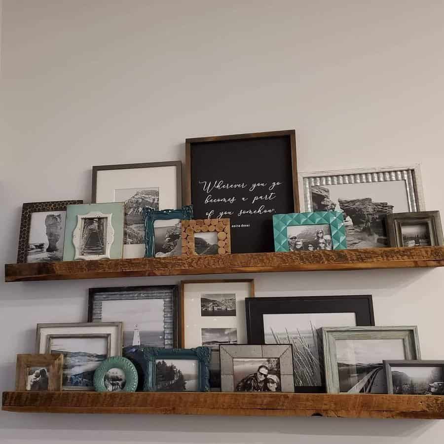 Two wooden shelves with various framed photos and a central quote: "Wherever you go becomes a part of you somehow"