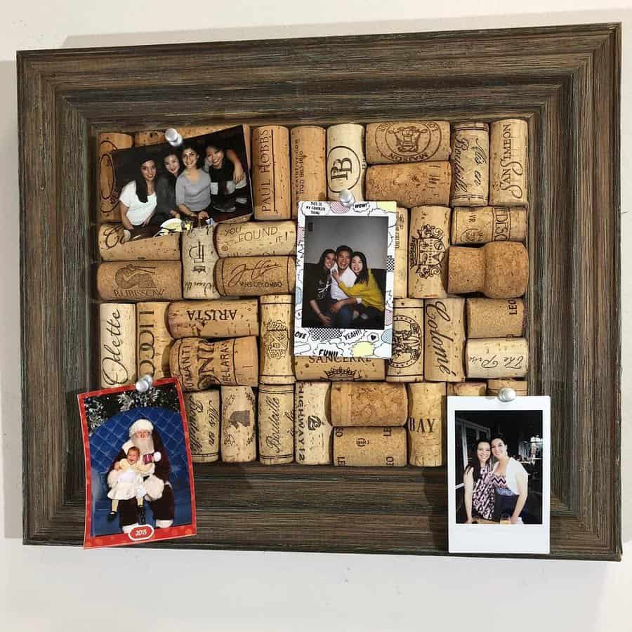 A cork bulletin board with four pinned family photos, framed with a rustic wooden border