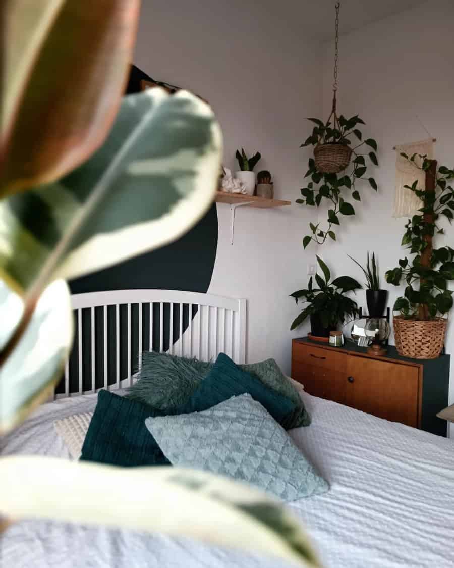 Green themed bedroom with indoor plants and textured pillows