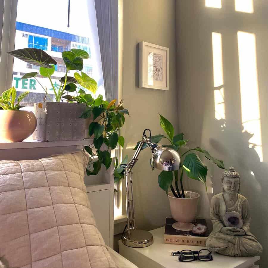 Sunny bedroom corner with plants and Buddha statue