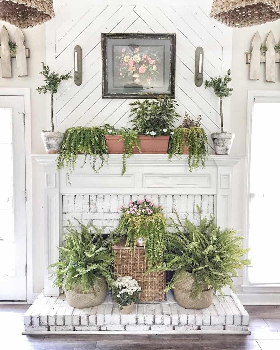 White brick fireplace adorned with lush ferns and potted plants, framed artwork above, and decorative wooden panels on the walls