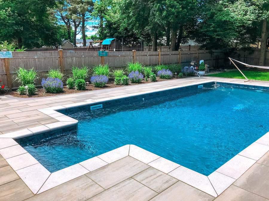 Swimming pool with paver deck and landscaped fence