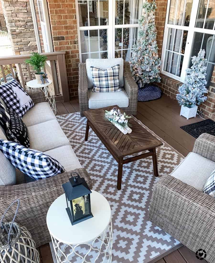 Cozy patio with wicker furniture, plaid cushions, and a holiday-decorated Christmas tree