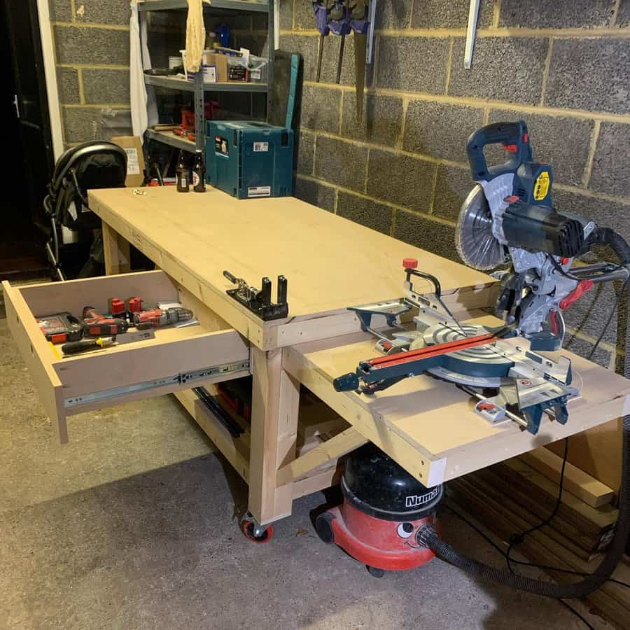 Carpentry workbench with open drawer and miter saw