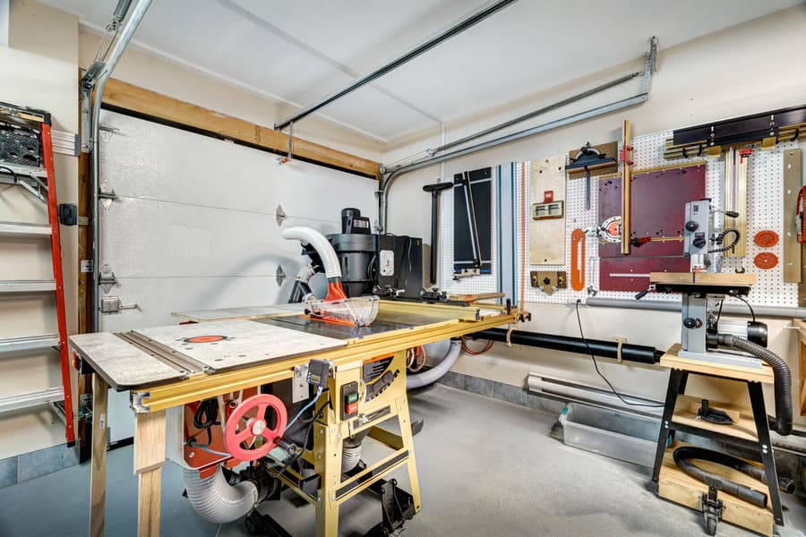 Well equipped garage workshop with table saw and pegboard