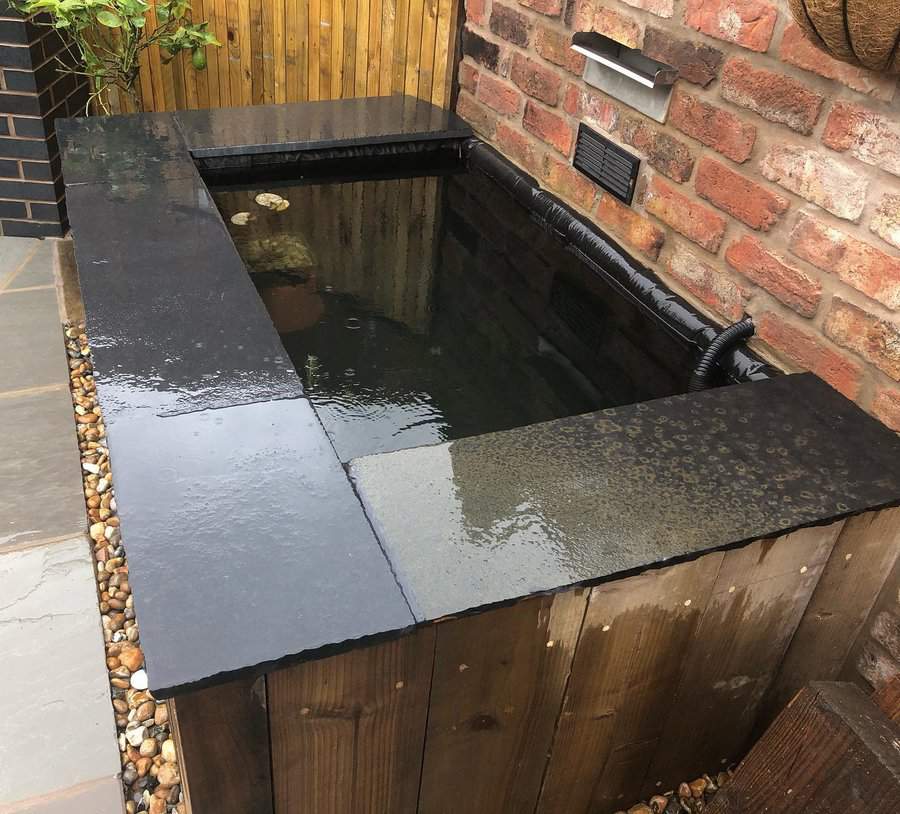 Contemporary raised pond with sleek stone finish