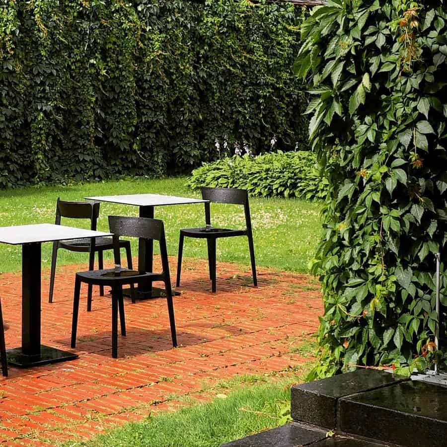 Garden patio with red bricks and black outdoor furniture